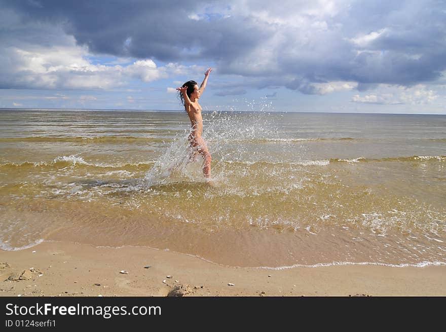 Naked girl running on the beach