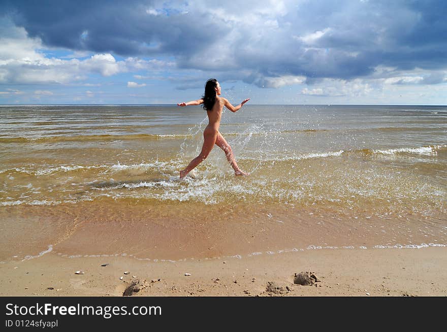 Naked girl running on the beach