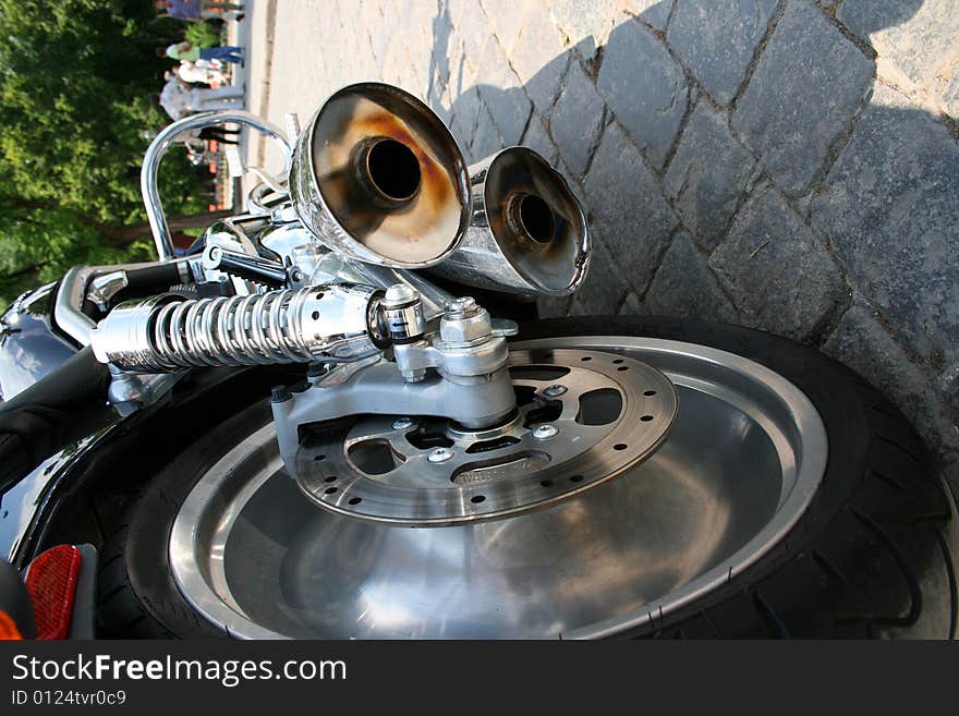 Close-up exhaust pipes and wheel of bike