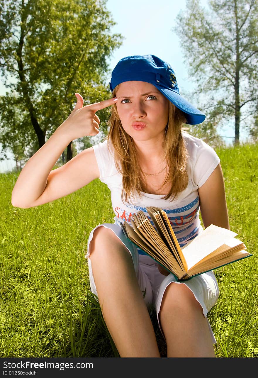 Pretty young girl unwilling to read a book