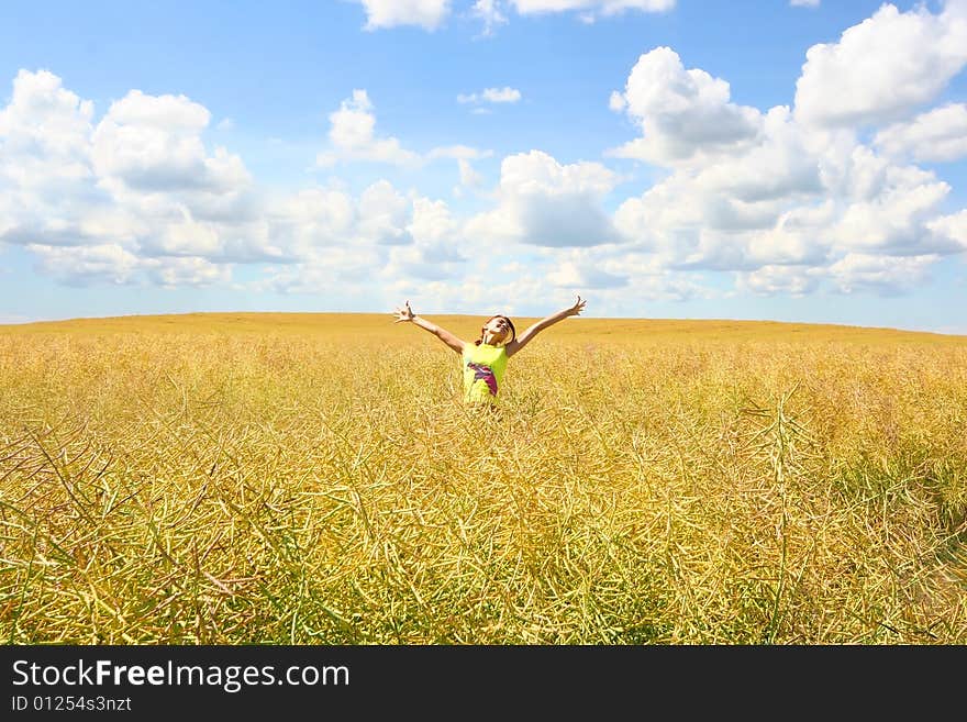 Happy young girl relaxing on yellow meadow