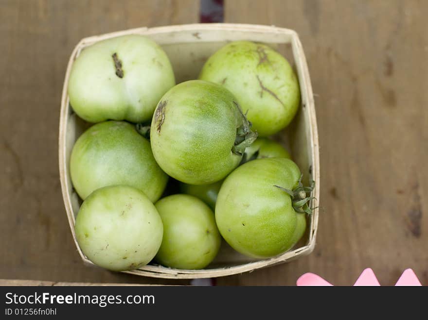 Pale green tomatoes in a wooden crate. Pale green tomatoes in a wooden crate.