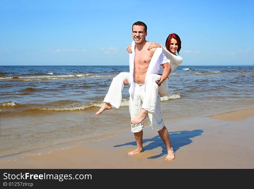 Beautiful yound couple relaxing on the beach. Beautiful yound couple relaxing on the beach