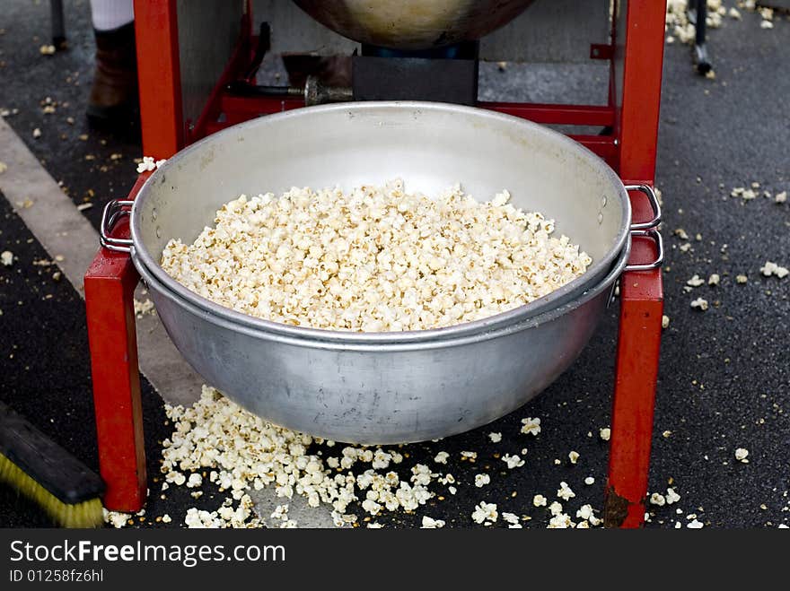 A tin basin filled with kettle corn at a county fair. A tin basin filled with kettle corn at a county fair.