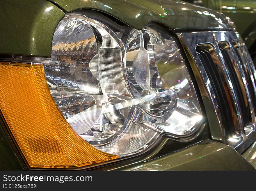 Close-up of a new modern car: head lamp and radiator. Close-up of a new modern car: head lamp and radiator