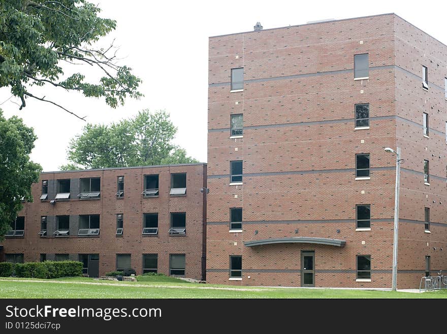 An exterior shot of a brick dormitory building. An exterior shot of a brick dormitory building.