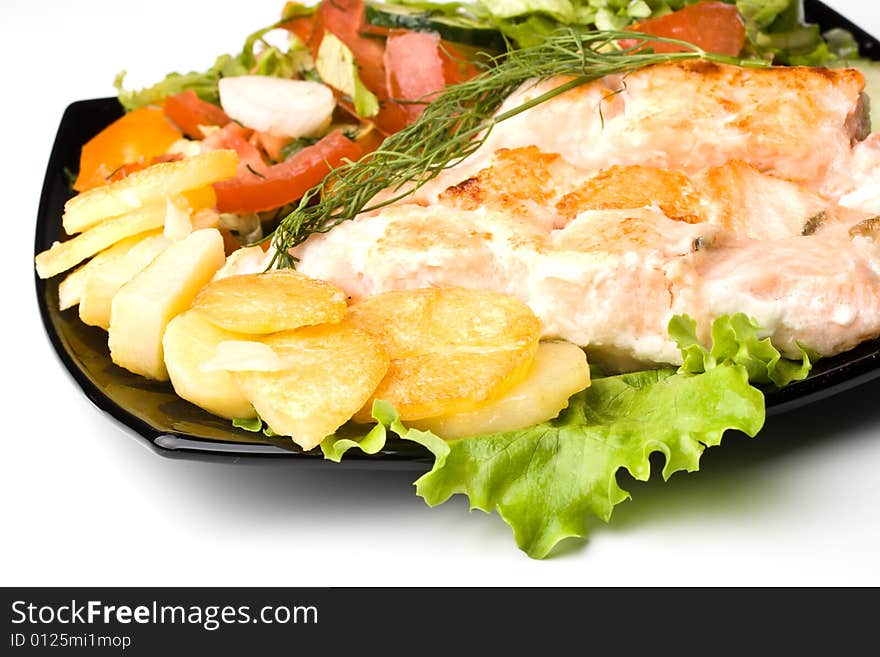 Stake from a salmon with vegetables on a plate. Closeup.