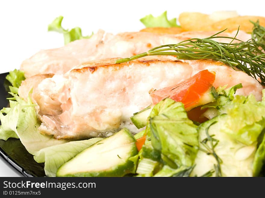 Stake from a salmon with vegetables on a plate. Closeup.