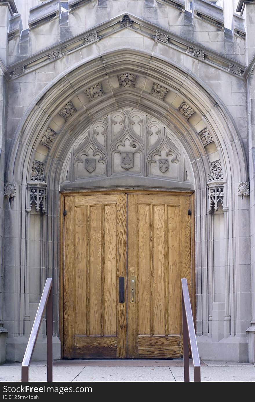 An ornate arch ensconcing a heavy wooden church door. An ornate arch ensconcing a heavy wooden church door.