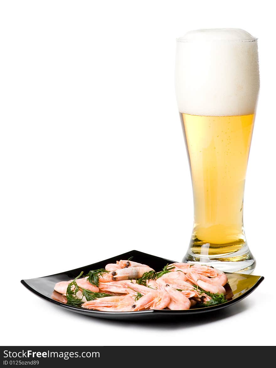 Beer in a glass and a dish with shrimps on a white background