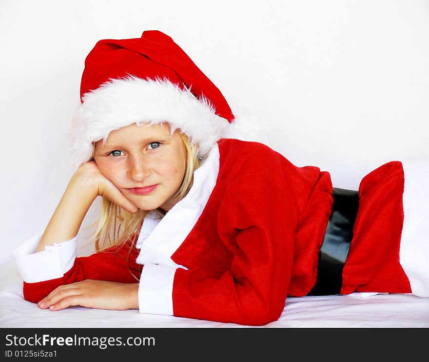 An adorable girl is lying and wearing a santa dress. An adorable girl is lying and wearing a santa dress.