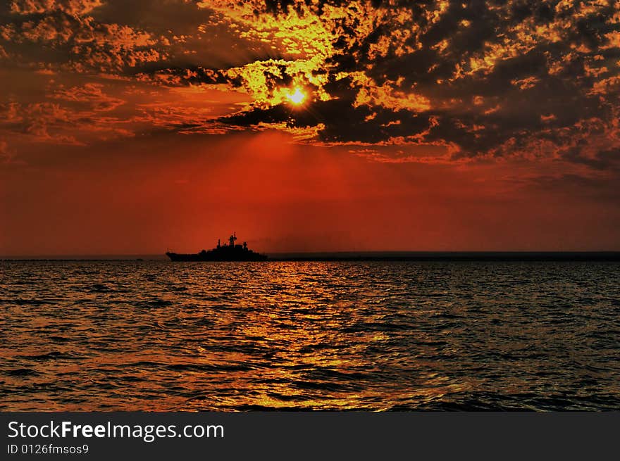 Picturesque decline in the black sea with a silhouette of the ship on horizon. Picturesque decline in the black sea with a silhouette of the ship on horizon