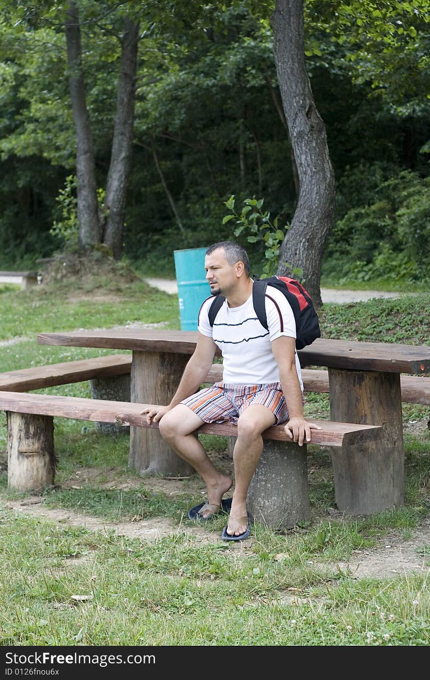 Tired man is sitting on a bench in park