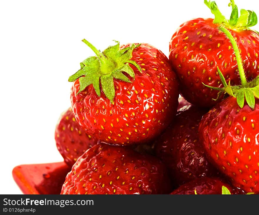 Strawberry on red plate over white background