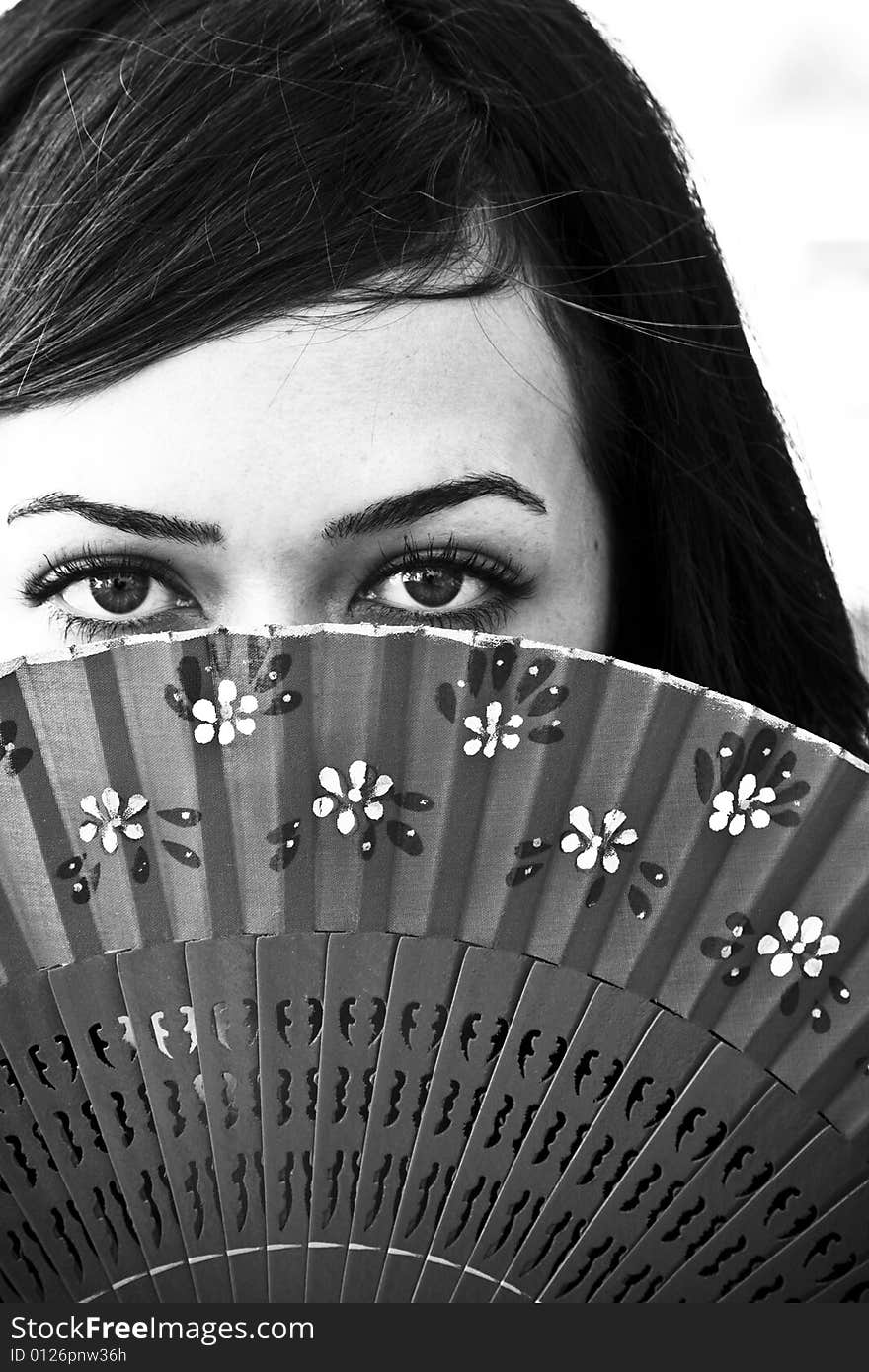 Spanish woman behind traditional fan. Spanish woman behind traditional fan.