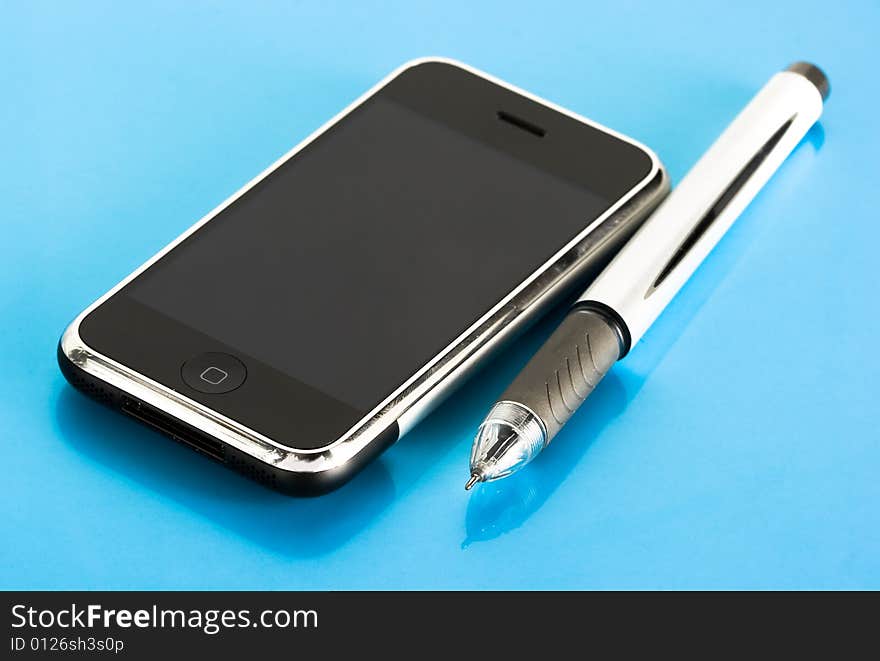 Pen and mobile phone on blue background. Pen and mobile phone on blue background