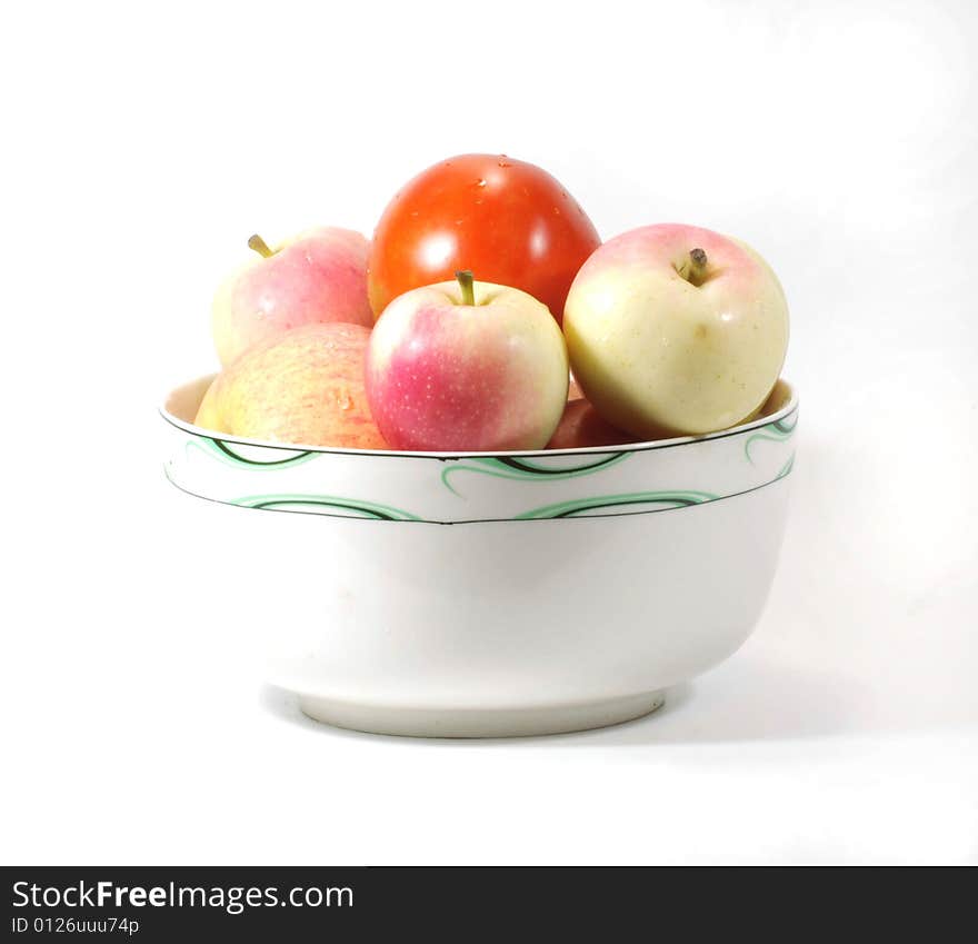 Apples and tomato  in a bowl on white background