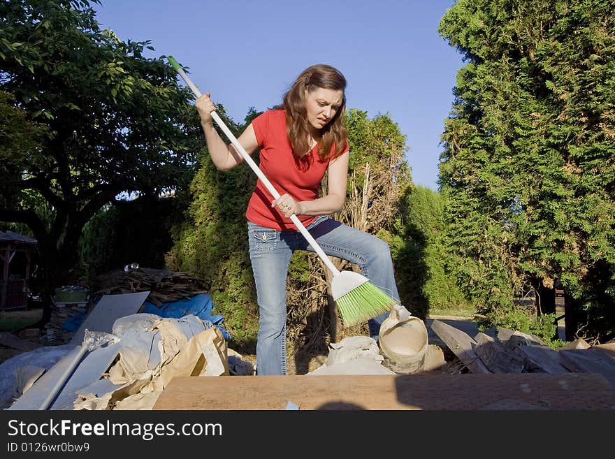 Woman Sweeping Through Garbage - Horizontal