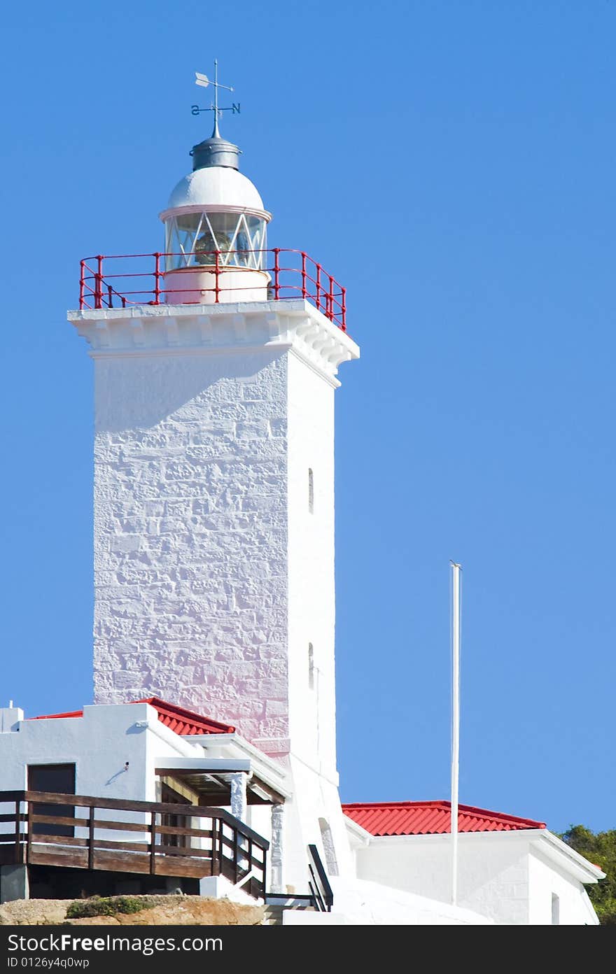 A newly renovated lighthouse and weather station against a bright blue sky.