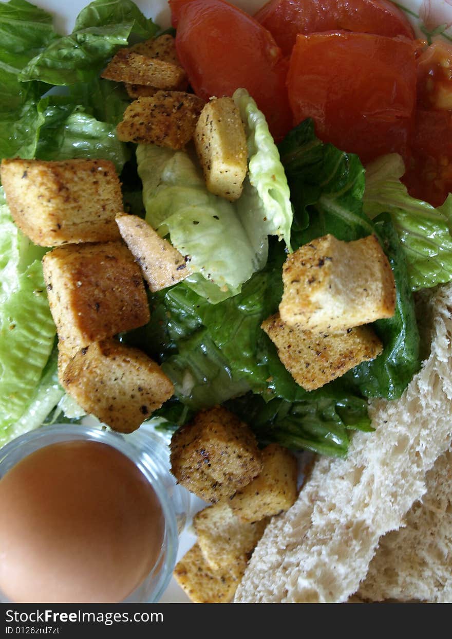 A Healthy Organic Breakfast consisting of an egg, lettuce, tomatoes, croûtons, bread.