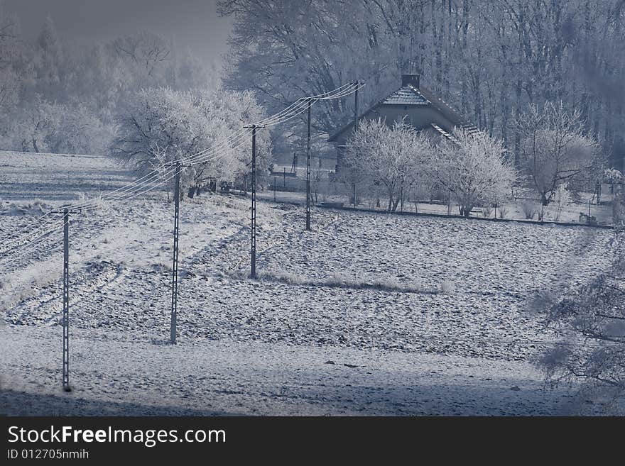 The winter on the village, fog in the background