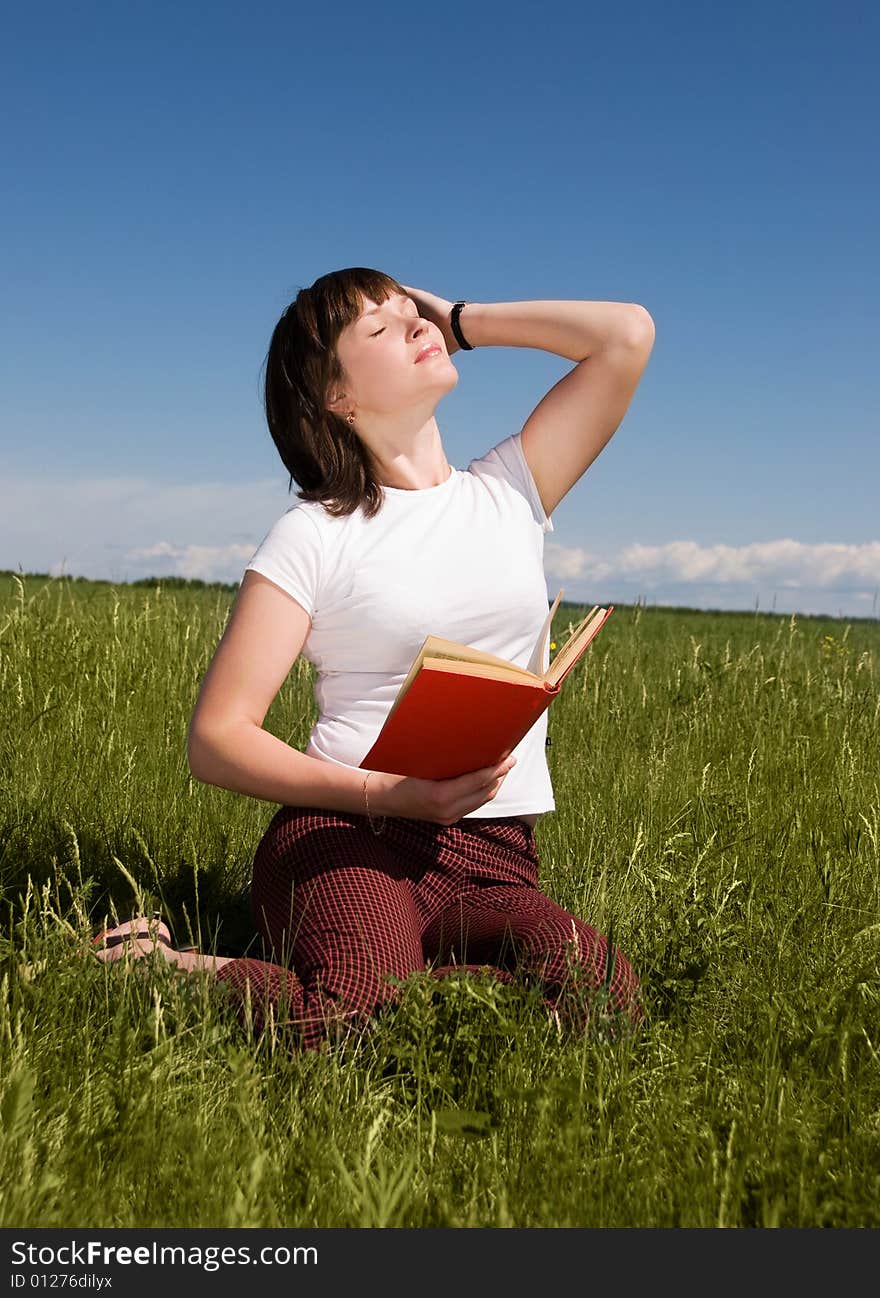 Girl relaxing on the grass with a book. Girl relaxing on the grass with a book