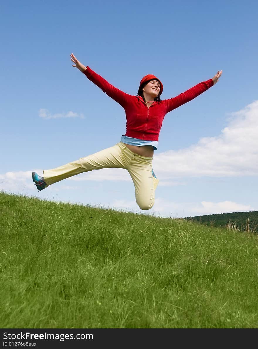 Happy jumping girl on the hill