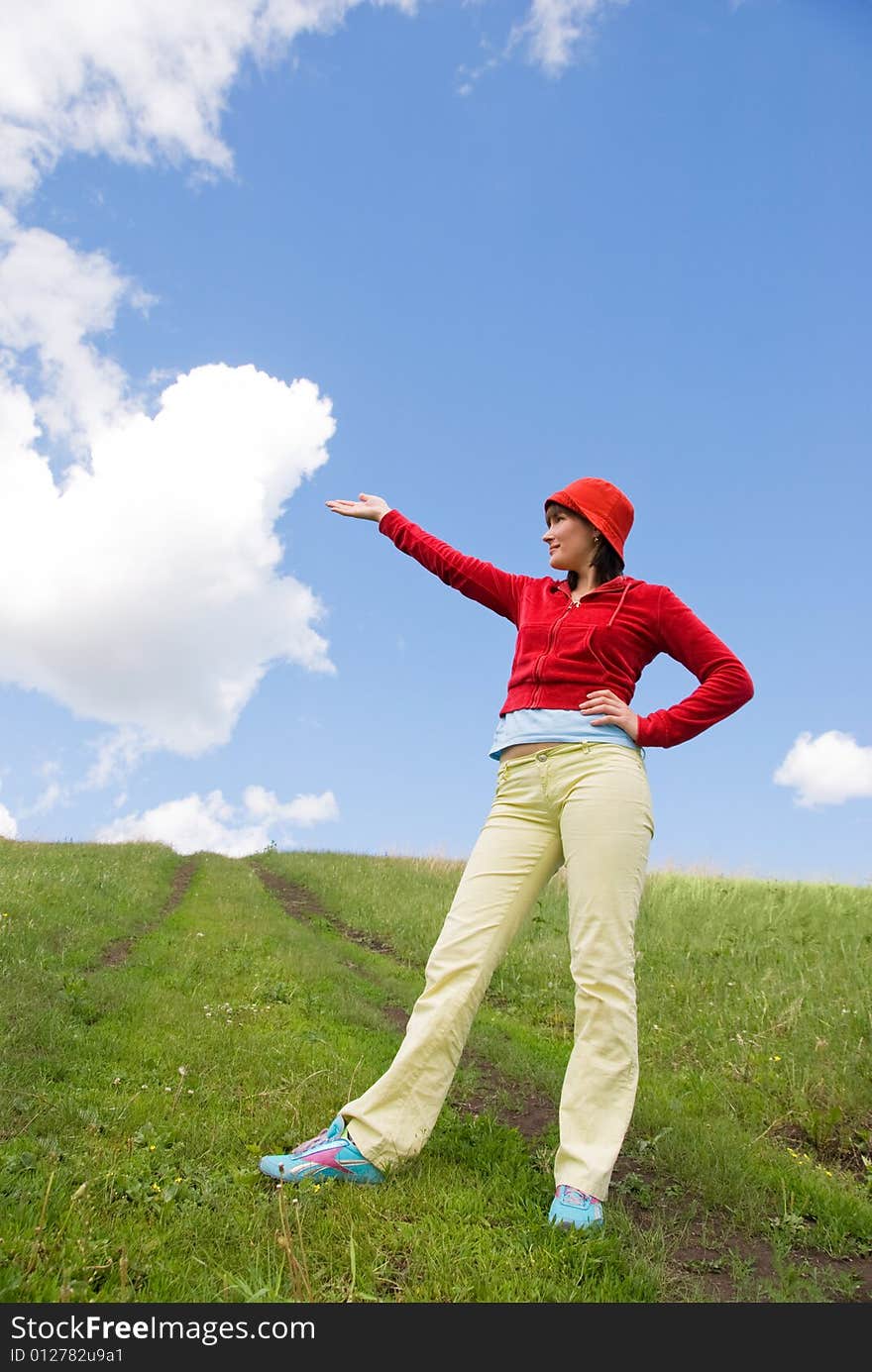 Young girl stands on the top of the hill and points at something. Young girl stands on the top of the hill and points at something