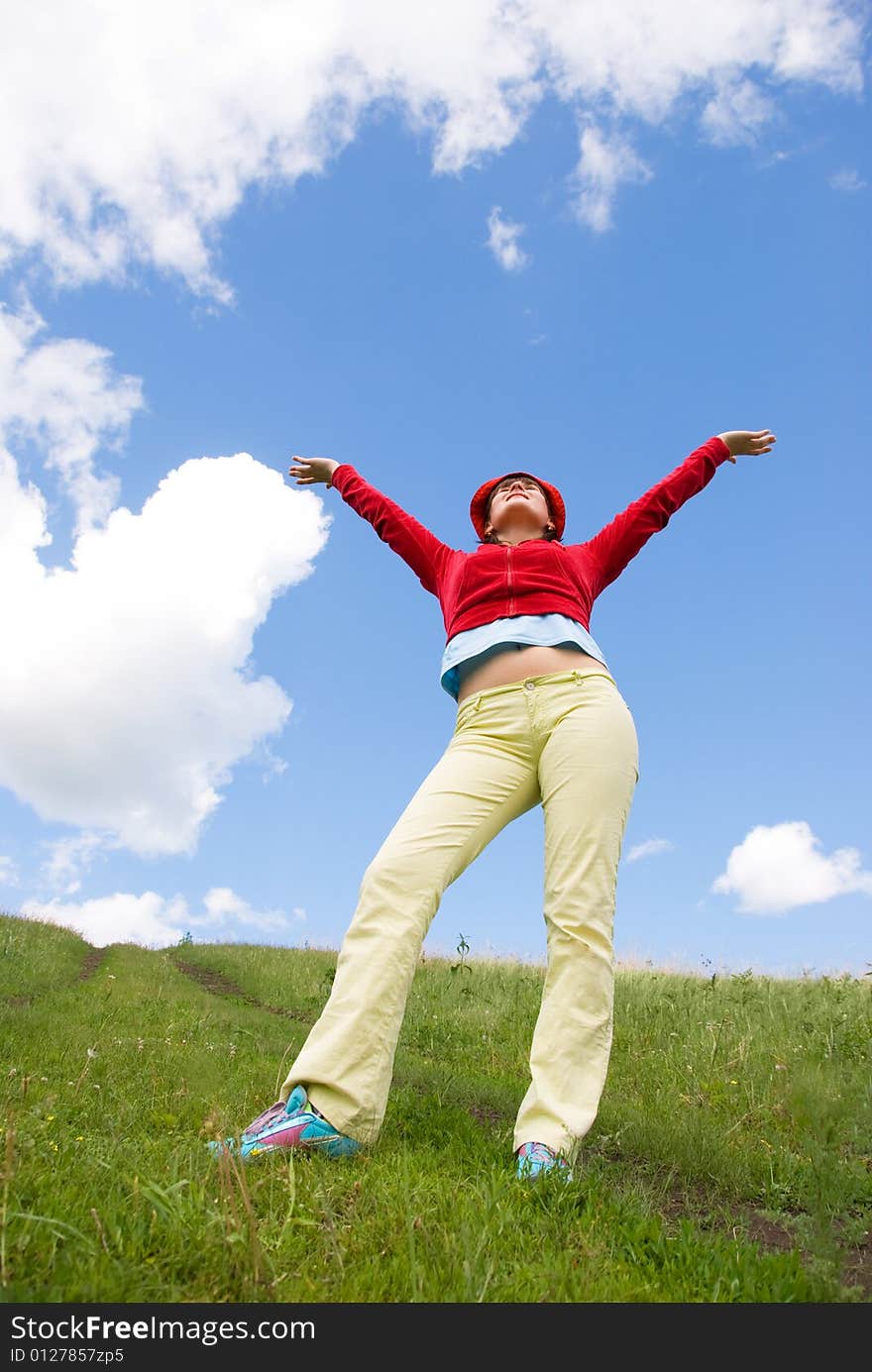 Happy girl standing on the hill and looking at the beautiful clouds. Happy girl standing on the hill and looking at the beautiful clouds