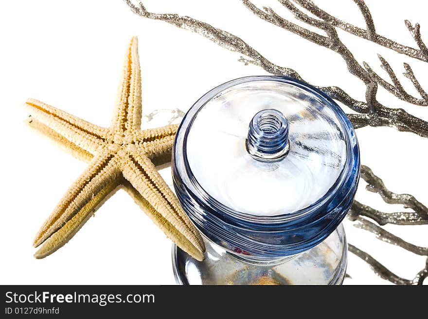 Blue bottle of perfume with starfish and corals