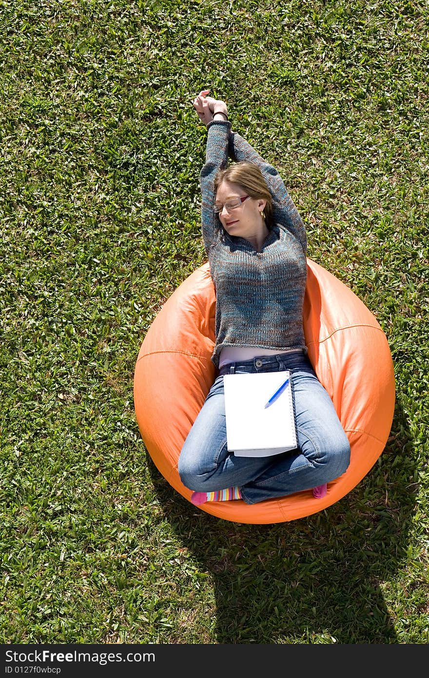 Beautiful woman working out sitting on orange puff