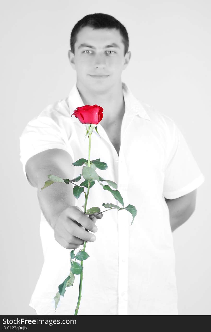 Young athlete man with red rose in hand isolated at white background. Young athlete man with red rose in hand isolated at white background