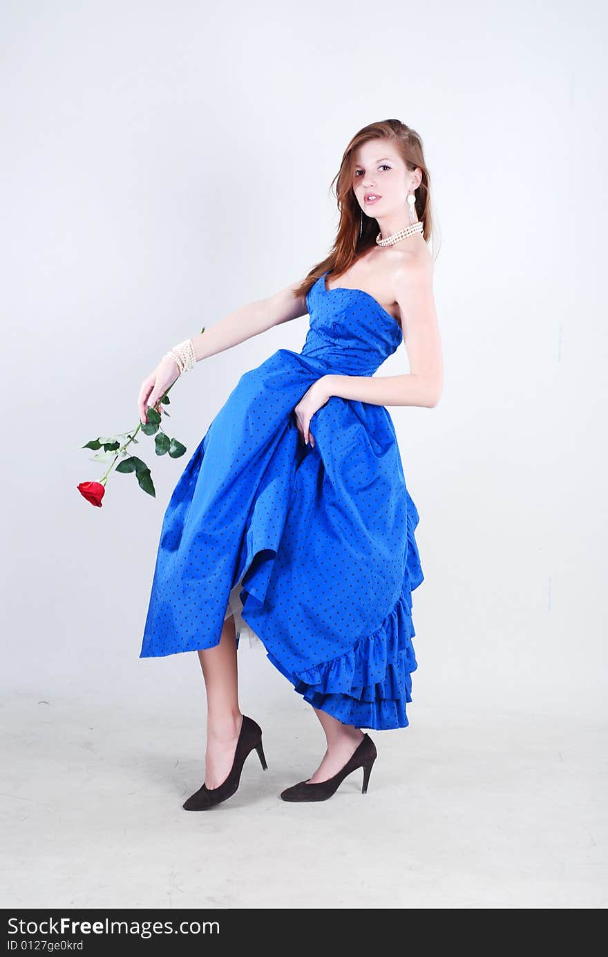 Beauty young woman in blue dress with rose at white isolated background