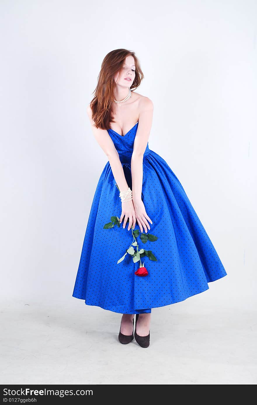 Beauty young woman in blue dress with rose at white isolated background