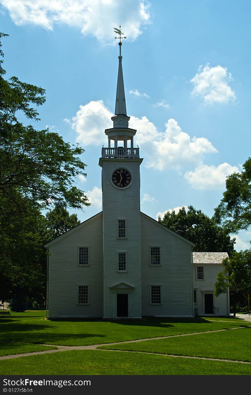 Classic new england white church with clock tower and weather vane