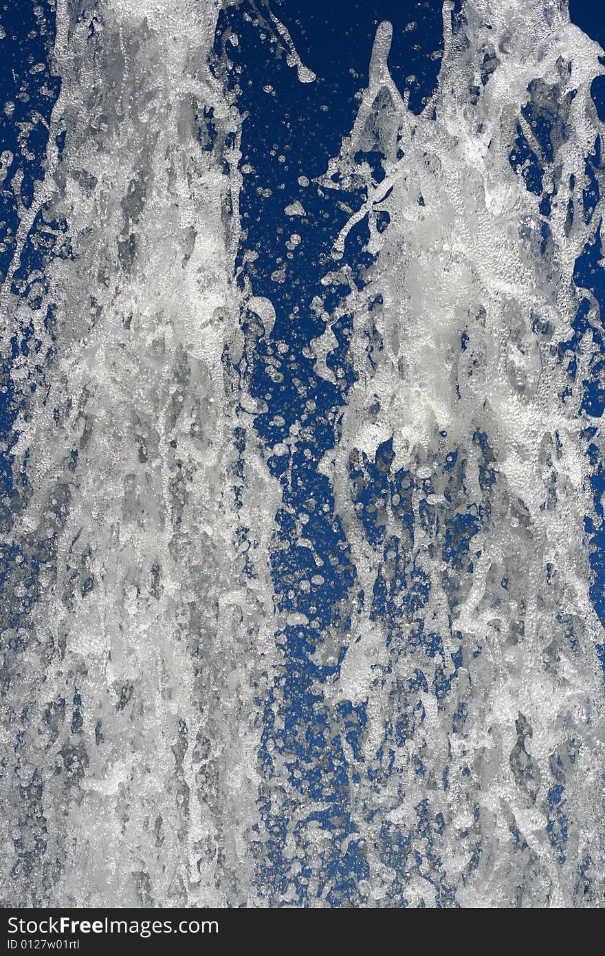 Fountain of water on a background of the blue sky. Fountain of water on a background of the blue sky