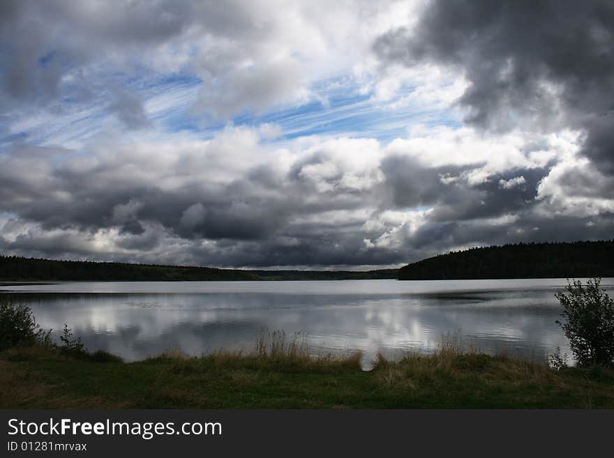 Pond under heavy grey clouds. Pond under heavy grey clouds