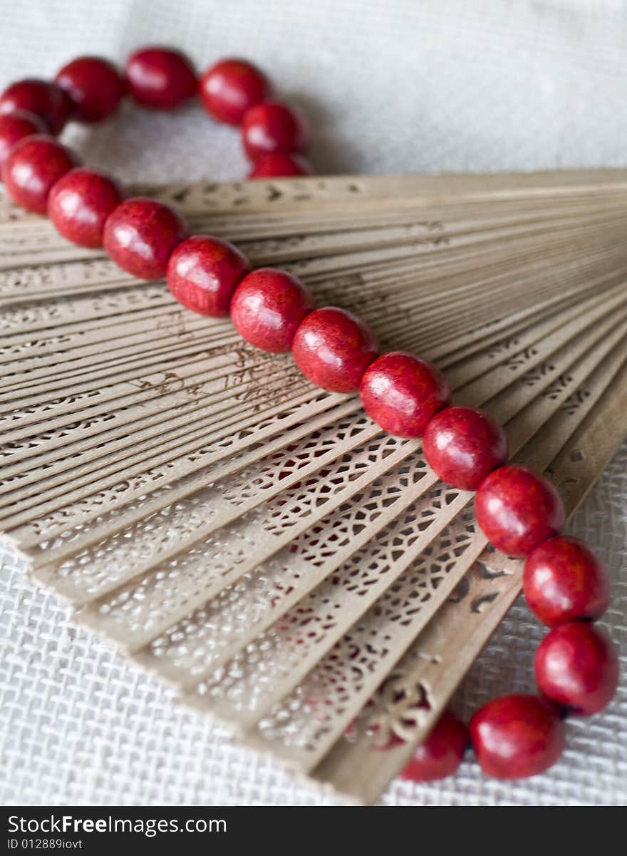 Red wooden beads on a wooden fan. Red wooden beads on a wooden fan