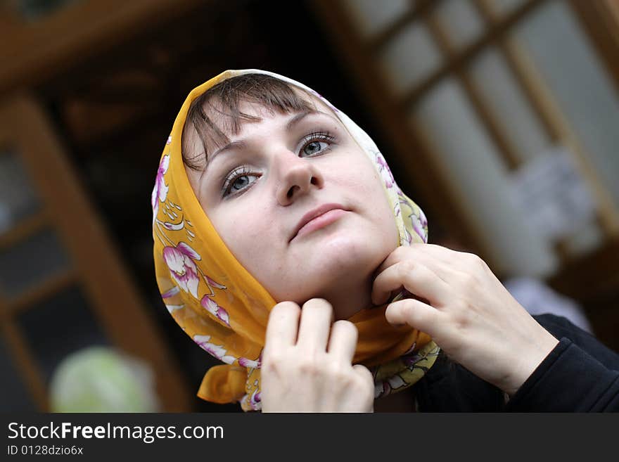 The girl ties a kerchief round one's head. The girl ties a kerchief round one's head