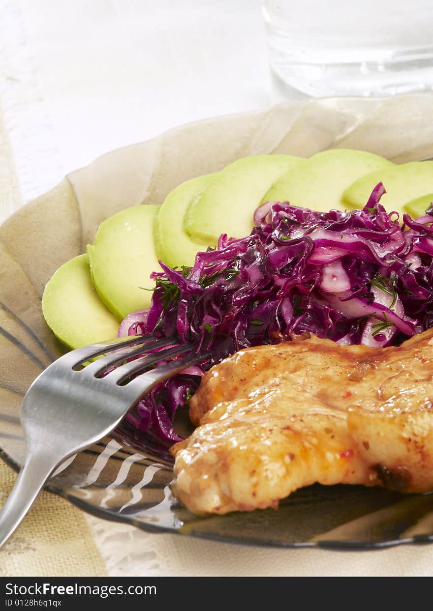 Pork steak with cabbage and sliced avocado