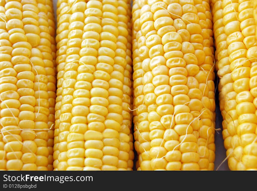 Ears of fresh corn as background