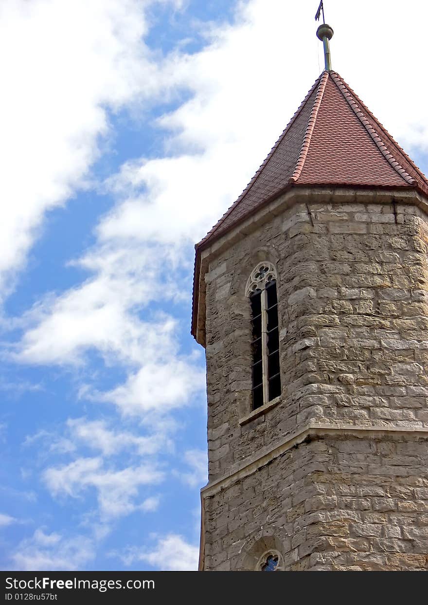 Historical church tower close up. The stone tower on background of the blue sky. Historical church tower close up. The stone tower on background of the blue sky.