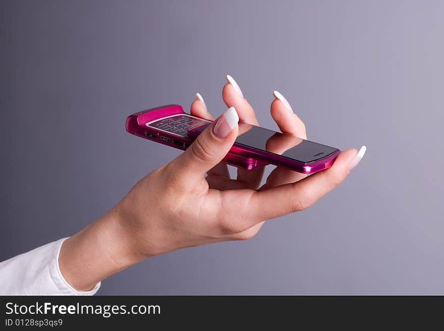 Female hand holding a pink mobile phone