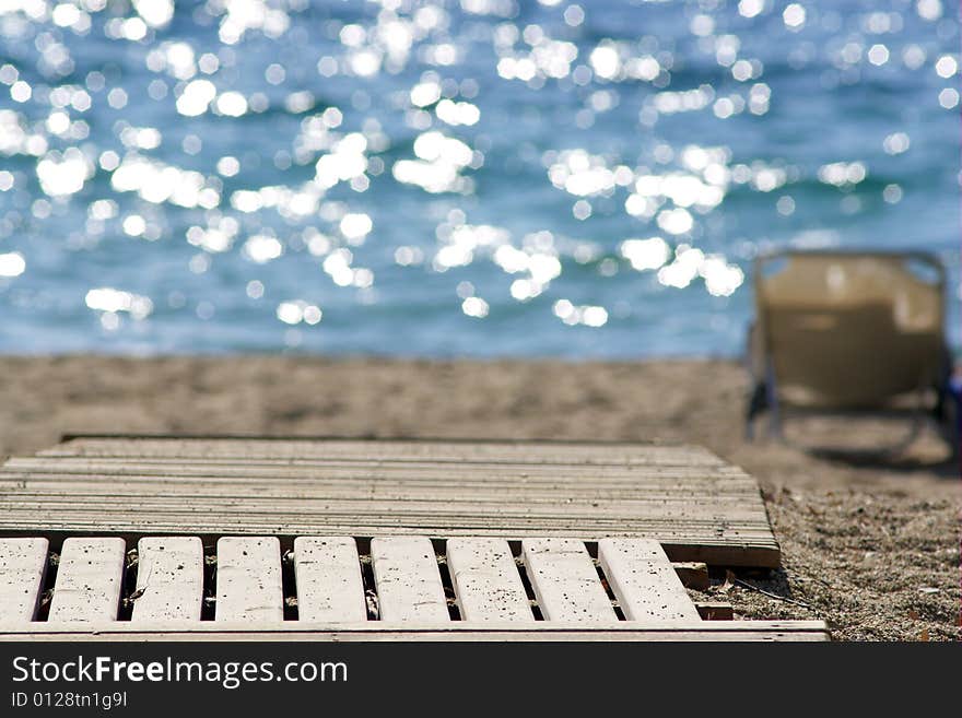 Wooden Walkway To A Sand Beach With Sun Beds