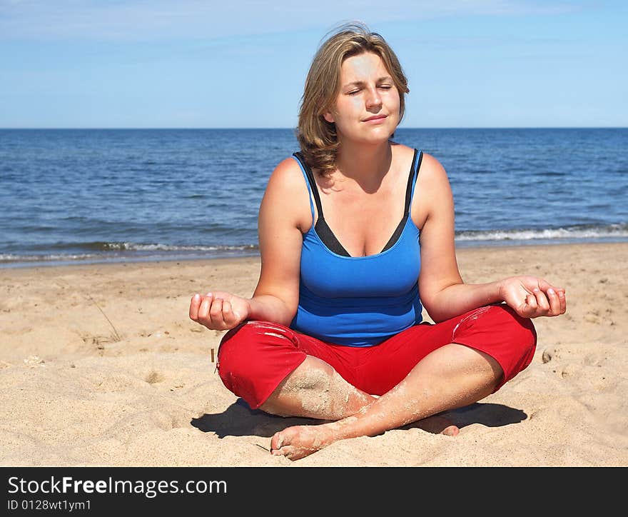 Woman is training yoga on the beach