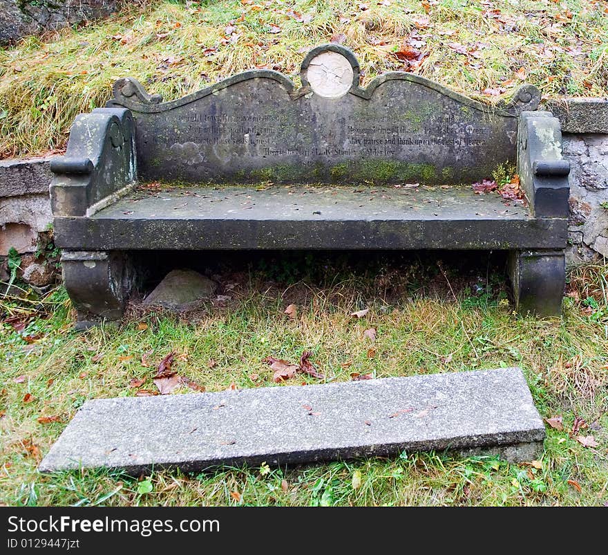 Inscription worn out by time on a stone bench near old church. Inscription worn out by time on a stone bench near old church