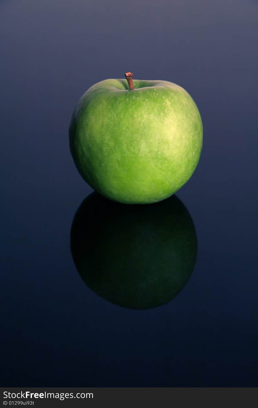 Green isolated apple on blue reflective background,. Green isolated apple on blue reflective background,