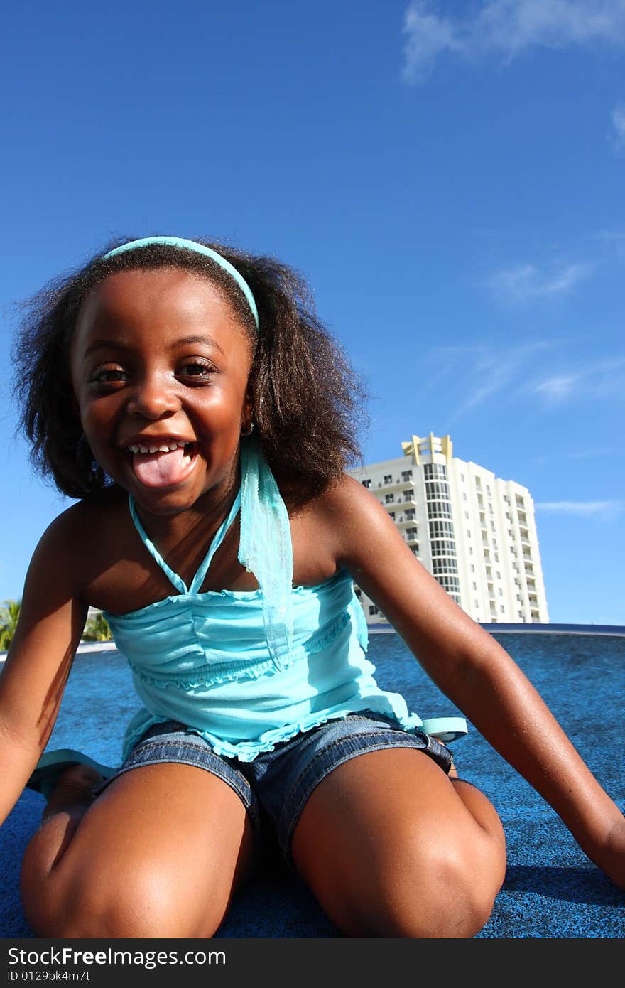 Young girl laughing with blue sky background which is usable as copyspace. Young girl laughing with blue sky background which is usable as copyspace.