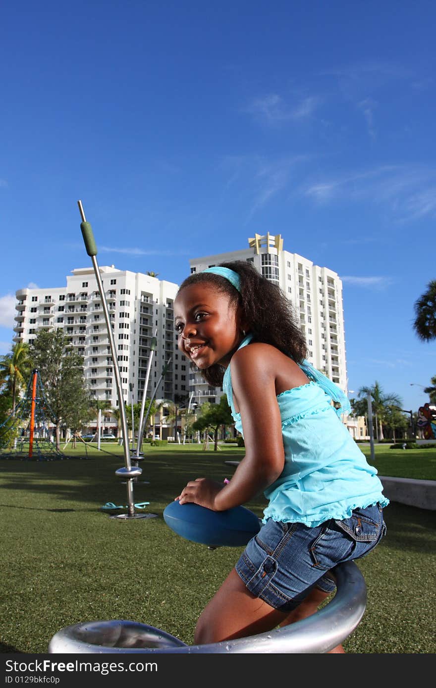 Young girl playing at a playground in the park. Young girl playing at a playground in the park.