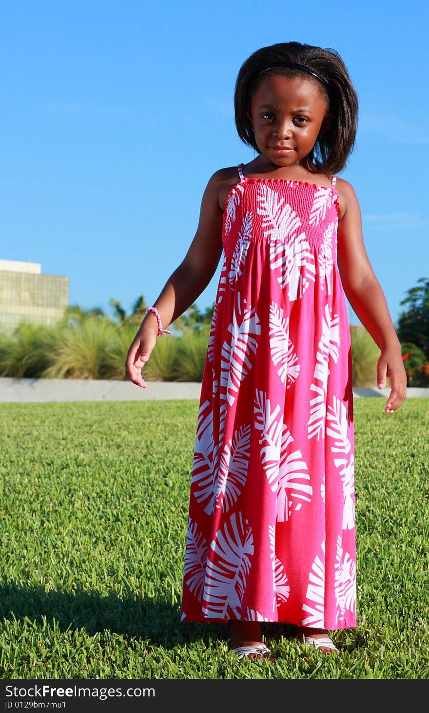 Young child standing on green grass looking at the camera. Young child standing on green grass looking at the camera.